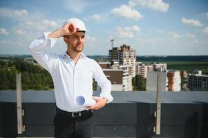 ritratto di uomo architetto a edificio luogo. fiducioso costruzione manager indossare elmetto protettivo. riuscito maturo civile ingegnere a costruzione luogo con copia spazio. foto