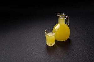 alcolizzato bevanda giallo limoncello nel un' piccolo bicchiere foto