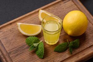 alcolizzato bevanda giallo limoncello nel un' piccolo bicchiere foto