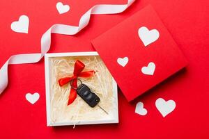 nero auto chiave nel un' presente scatola con un' nastro e rosso cuore su colorato sfondo. San Valentino giorno composizione superiore Visualizza foto