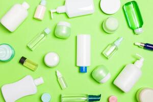 gruppo di plastica cura del corpo bottiglia piatto posare composizione con cosmetico prodotti su verde sfondo vuoto spazio per voi design. impostato di bianca cosmetico contenitori, superiore Visualizza con copia spazio foto