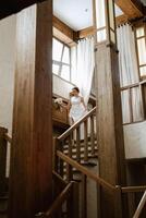 giovane ragazza sposa andando giù il le scale foto