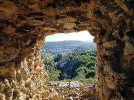 Visualizza attraverso il finestra di un antico pietra Torre su un' naturale paesaggio. foto