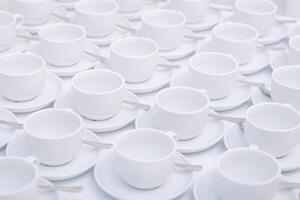 bianca tè tazze con piattino in piedi su il tavolo. foto