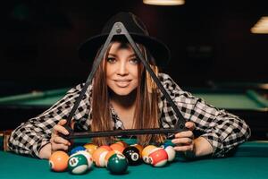 un' ragazza nel un' cappello nel un' biliardo club con palle nel sua mani.che.giocano biliardo foto