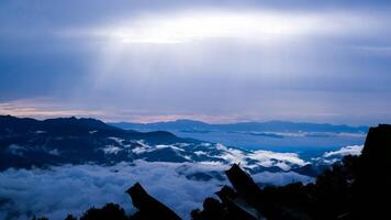 aereo Visualizza al di sopra di il montagne con mare di nebbia durante mattina Alba nel blu cielo. mare di nuvole in giro montagna picchi a Alba. nascosto viaggio nel settentrionale Tailandia. foto