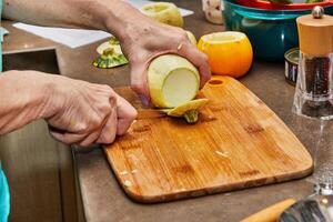 capocuoco tagli il giro zucchine su di legno tavola nel il casa cucina foto