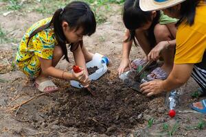 poco ragazza piantare impianti nel pentole a partire dal riciclato acqua bottiglie nel il Giardino dietro la casa. riciclare acqua bottiglia pentola, giardinaggio attività per bambini. raccolta differenziata di plastica rifiuto foto