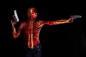 sensuale donna vestito nel un' scheletro costume Tenere Due pistole foto