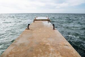 ferro molo nel il infinito mare. un vecchio frangiflutti nel il mare. un' promettente tiro di il mare, chiaro cieli e luminosa blu acqua. foto