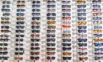 i saldi cremagliera di occhiali da sole. un' colorato Schermo di occhiali da sole per vendita foto
