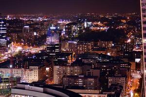 Visualizza di a notte bicchiere edifici e moderno attività commerciale grattacieli. Visualizza di moderno grattacieli e attività commerciale edifici nel centro. grande città a notte. foto