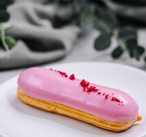 eclairs con rosa Smalto su un' bianca piatto foto