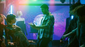 giovane adulti in movimento a discoteca festa, avendo divertimento con palcoscenico luci e impaurito musica a discoteca. allegro uomini e donne mostrando via danza si sposta per divertente breakdance battaglia. tripode sparo. foto