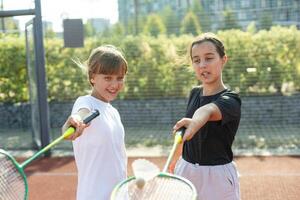 giovane ragazze, atleti tremante mani prima gioco sessione. giocando tennis su caldo soleggiato giorno a Aperto aria tennis Tribunale. concetto di sport, passatempo, attivo stile di vita, Salute, resistenza e forza, anno Domini foto