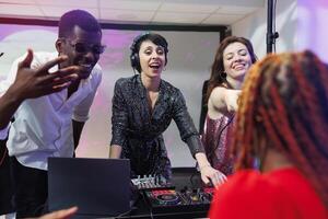 eccitato musicisti gruppo musicale l'esecuzione su palcoscenico e coinvolgente folla per festa nel discoteca. dj giocando utilizzando suono miscelatore stazione a vivere elettronico musica concerto Festival a discoteca nel club foto