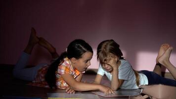 poco ragazze lettura un' libro nel vivente camera. inteligente studentesse fare loro compiti a casa dopo scuola. formazione scolastica e distanza apprendimento per bambini. homeschooling durante quarantena. restare a casa intrattenimento. foto