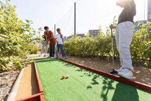 giocatori di golf con genitori giocando golf a soleggiato giorno foto