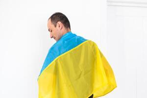 contento giovane uomo con ucraino bandiera su bianca sfondo foto