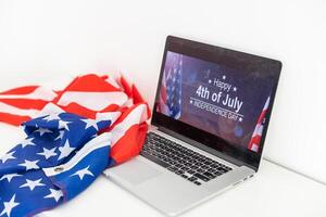il computer portatile con iscrizione 4 luglio iscrizione al di sopra di americano bandiera. indipendenza giorno. foto