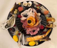 un' piatto con vario frutti di mare su esso foto