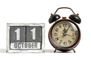 ottobre 11 su di legno calendario con allarme orologio bianca sfondo. foto