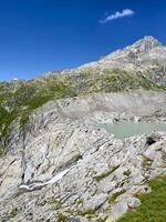 un' montagna con un' lago e un' verde erboso la zona foto