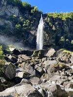 un' cascata è visto nel il mezzo di un' roccioso montagna foto