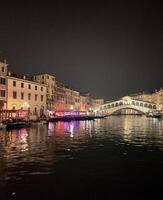 un' fiume a notte con un' ponte al di sopra di esso foto