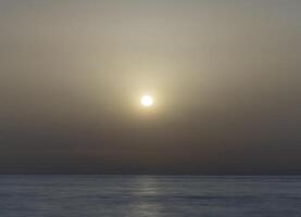 il sole è ambientazione al di sopra di il oceano foto