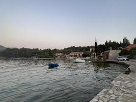 un' barca è attraccato su il riva di un' lago foto