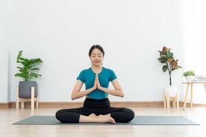 sottile donna praticante yoga su camera a condominio o casa. asiatico donna fare esercizi nel mattina. equilibrio, meditazione, rilassamento, calma, bene Salute, felice, relax, salutare stile di vita, dieta, sottile foto