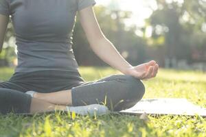 donna praticante meditare su il parco. asiatico donna fare esercizi nel mattina. equilibrio, ricreazione, rilassamento, calma, bene Salute, felice, relax, salutare stile di vita, ridurre fatica, tranquillo, calmo, atteggiamento. foto