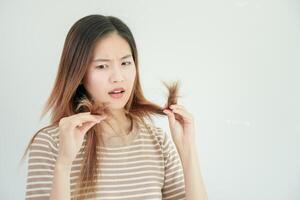 asiatico donna molto triste e irritato guardare a danneggiato capelli, capelli perdita, capelli diradamento problema, vitamina carenza, calvizie, postpartum, biotina, zinco, mestruale o endocrino disturbi, ormonale squilibrio foto