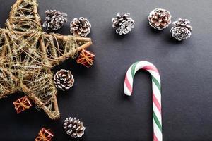 caramelle di canna di natale su sfondo nero e decorazioni natalizie foto
