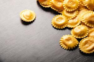 cucinare i ravioli italiani sulla tavola di legno. vista dall'alto con spazio di copia. foto