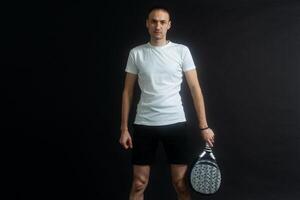 bellissimo uomo giocando pagaia tennis, racchetta nel mano concentrato Guarda. giovane sportivo ragazzo pronto per il incontro. focalizzata padel atleta pronto per ricevere il sfera. sport, Salute, gioventù e tempo libero concetto foto