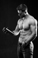 molto muscolare sportivo tipo Tenere proteina bere. uomo con nudo torso. atletico corpo. sport e sport nutrizione concetto. nero e bianca foto. foto