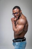 sexy muscolare uomo in piedi pensieroso con nudo torso. nudo bodybuilder in posa per telecamera a studio. foto
