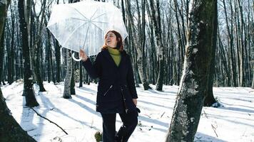 signora con ombrello nel il nevoso foresta foto