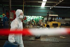 lavoratori indossare sicurezza tute e gas maschere sotto ispezione di chimico carri armati nel industriale opera con pericoloso sostanze chimiche. foto