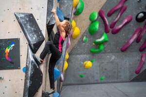 determinato ragazza arrampicata artificiale parete a roccia scalata centro foto