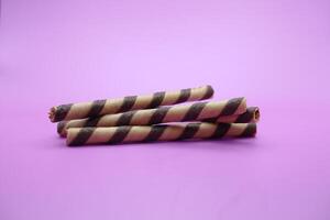 wafer bastone isolato viola sfondo. 2 cioccolato aromatizzato wafer bastoni. foto