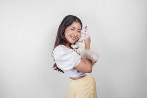 ritratto di giovane asiatico donna Tenere carino bambola di pezza gatto con blu occhi. femmina abbracciare sua carino lungo capelli gattino isolato di bianca sfondo. adorabile domestico animale domestico concetto. foto