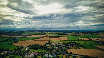 drammatico nuvole al di sopra di un' sereno rurale paesaggio con i campi e un' piccolo villaggio nel yorkshire brughiere. foto