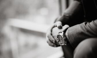 nero e bianca foto di un' uomo d'affari nel un' completo da uomo con un' orologio su il suo mano. sfocato sfondo. avvicinamento