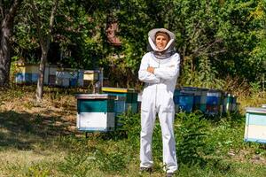 ritratto di contento maschio apicoltore. apicoltore è Lavorando con api e alveari su il apiario. foto