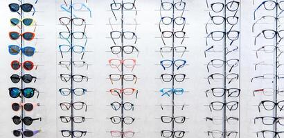 occhiali da sole nel un' negozio. vetrina con spettacoli nel moderno oftalmico negozio. foto