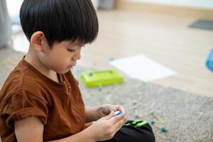 asiatico ragazzo giocando con plastilina nel il camera foto