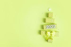 biglietto di auguri con albero di natale astratto fatto di scatole regalo e numeri 2022 per buon natale e capodanno foto